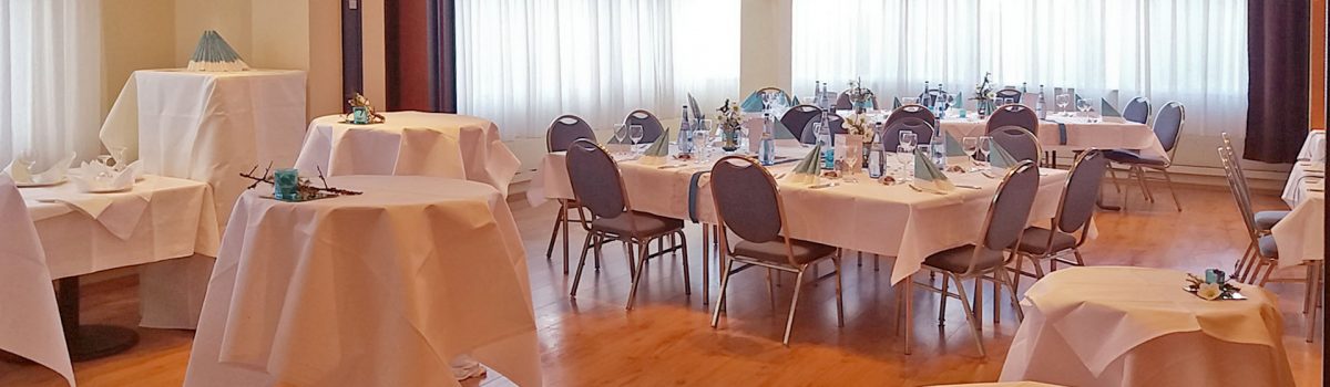 Eingedeckte Tische mit Bistrotischen im Vordergrund