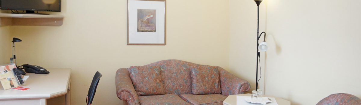 Doppelzimmer mit Sofa, Schreibtisch und TV