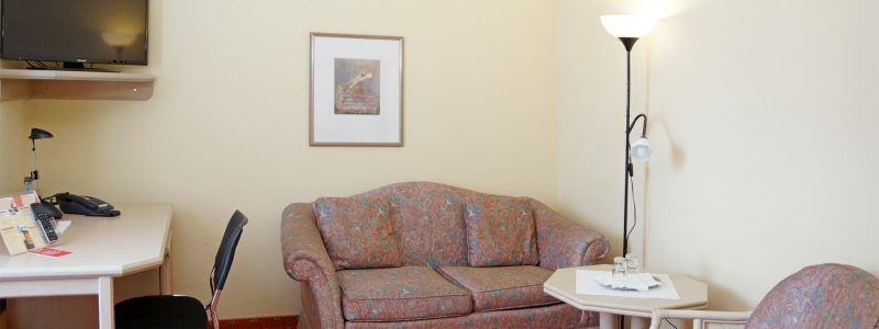 Doppelzimmer mit Sofa, Schreibtisch und TV