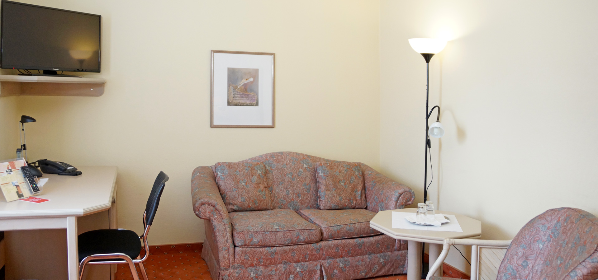 Doppelzimmer mit Sofa, Schreibtisch und TV